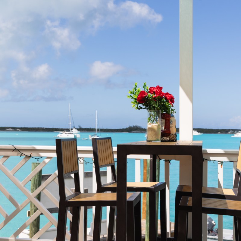Outdoor dining area with a table, chairs, and ocean view.